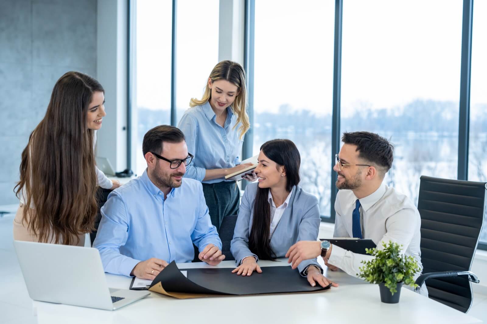 Team of professionals reviewing proposal documents together in a modern office